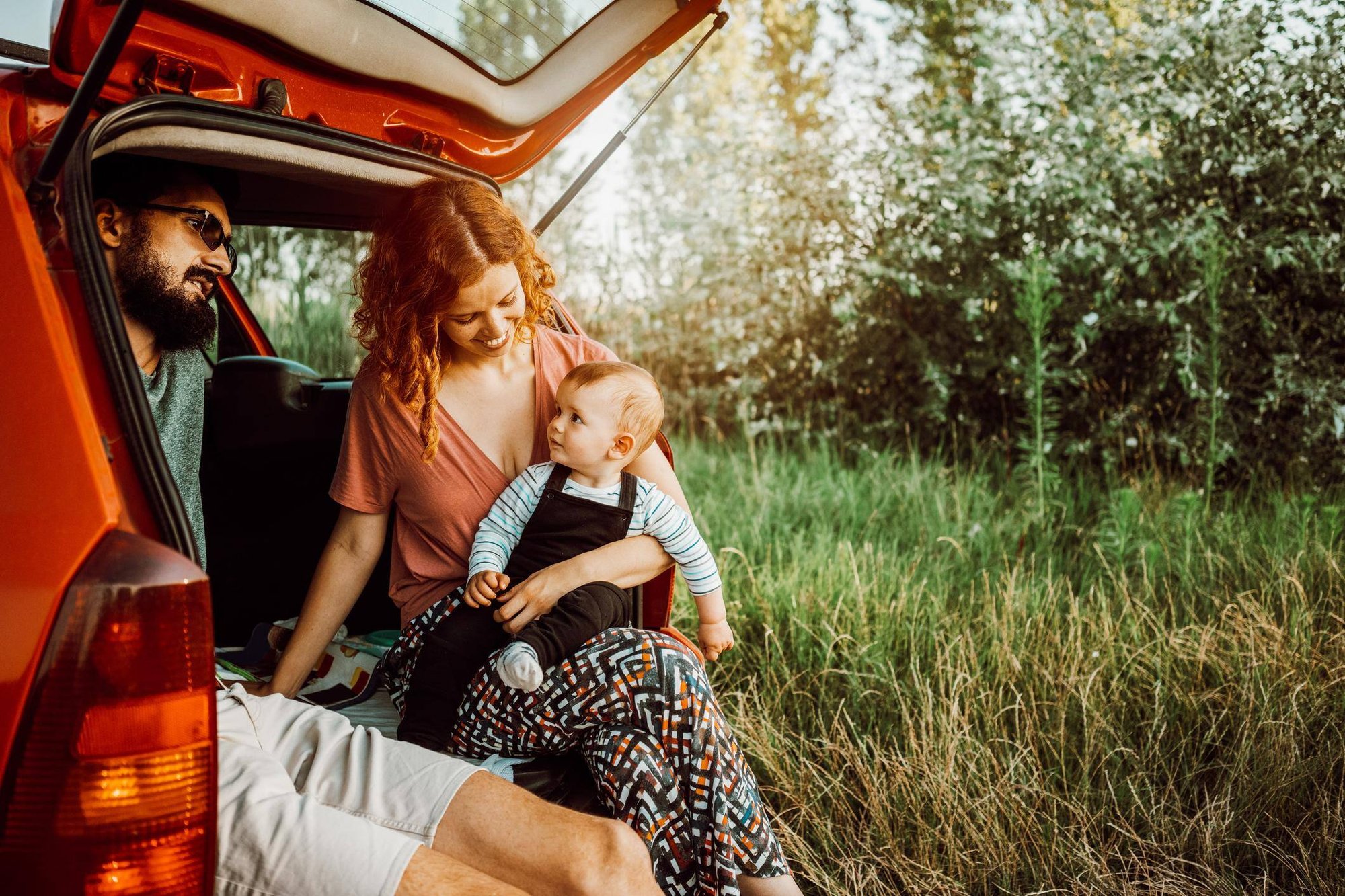 Couple and baby enjoying nature in back of SUV (NXPowerLite Copy)